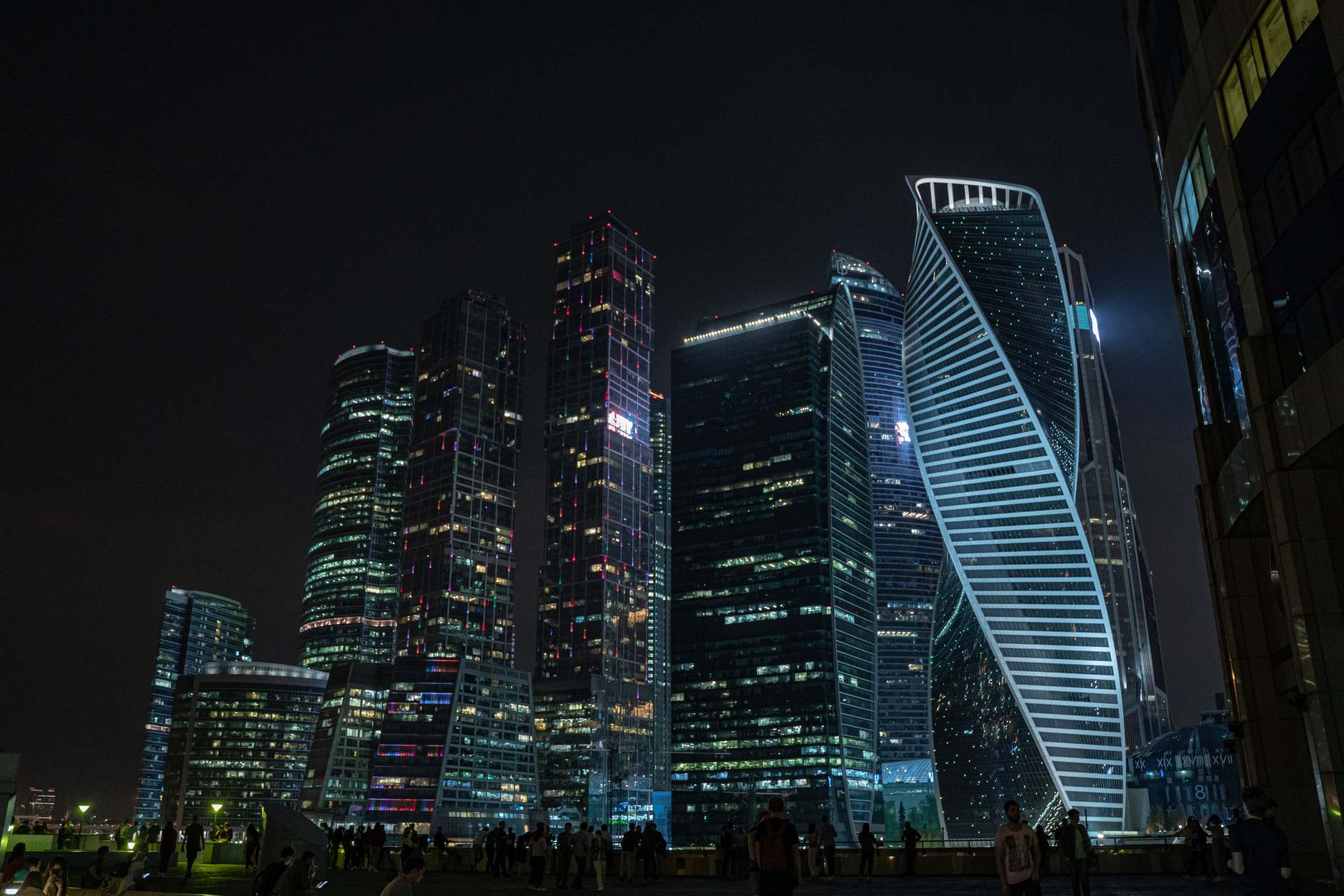 Financial district office towers lit at night, illuminated skyscrapers against a dark sky
